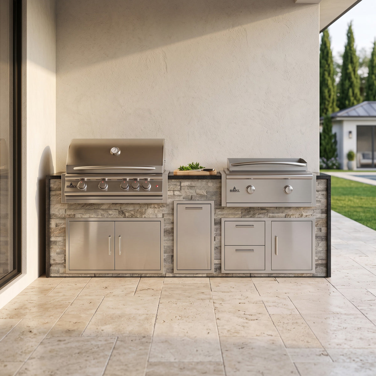 Tuscan Hearth grill and griddle island with Charred Onyx granite top on a travertine patio beside the house with the pool behind