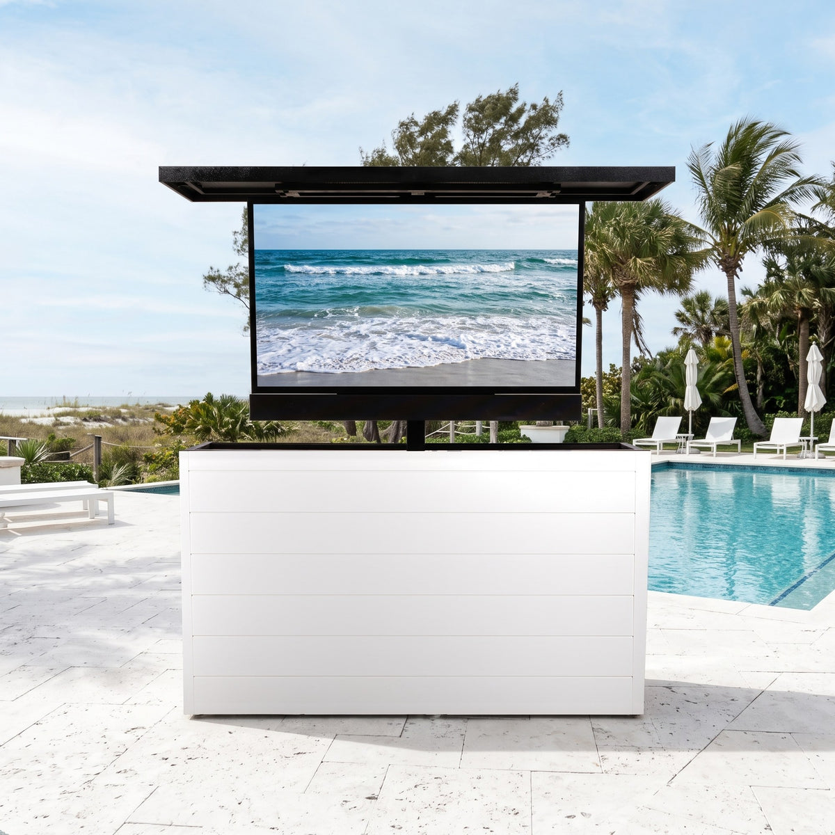 Alpine Crest 6 inch ArtisanPlank outdoor TV lift cabinet with the TV raised on a coastal pool deck with palms