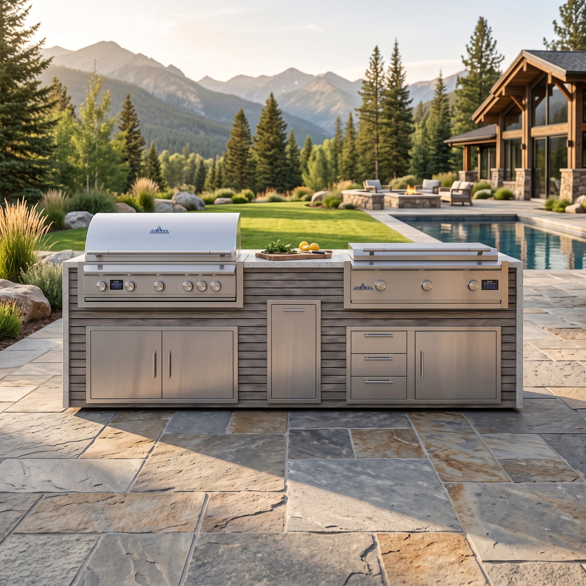 Drifted Cypress grill and griddle island with Frosted Ember granite top on a flagstone patio by the pool with pine trees and mountains beyond