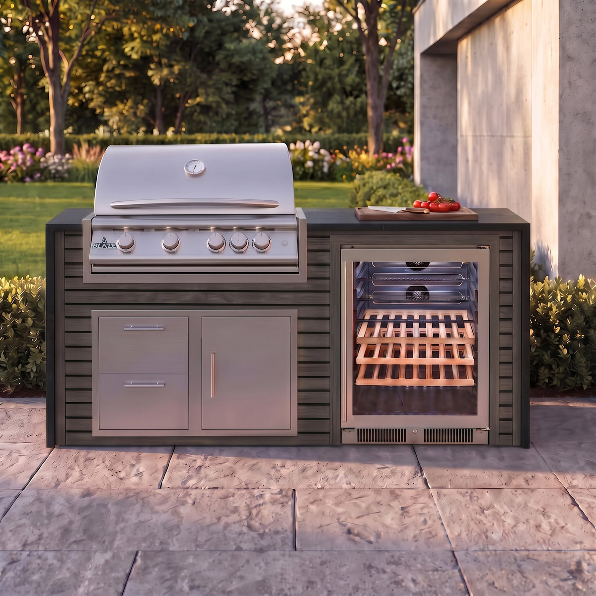Cindered Ash outdoor kitchen with Charred Onyx granite countertop on a stone paver patio beside a backyard garden