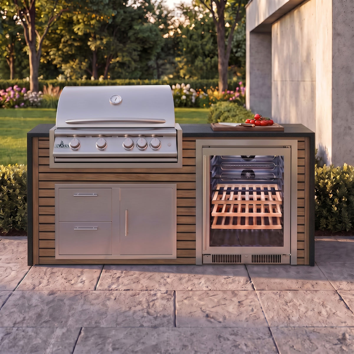 Warmed Acacia outdoor kitchen with Charred Onyx granite countertop on a stone paver patio beside a backyard garden
