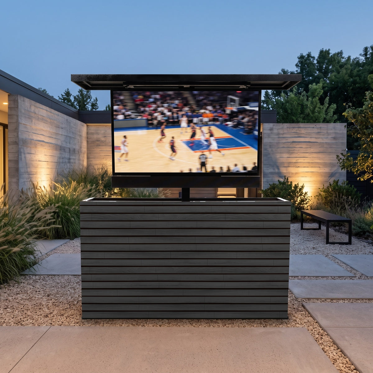 Cindered Ash 2 inch horizontal ArtisanPlank outdoor TV lift cabinet with the TV raised in a modern concrete courtyard at dusk