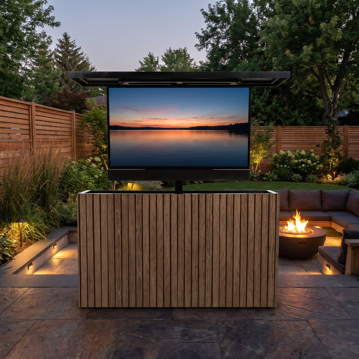 Umbered Oak 2 inch vertical ArtisanPlank outdoor TV lift cabinet with the TV raised on a backyard patio beside a fire table at dusk